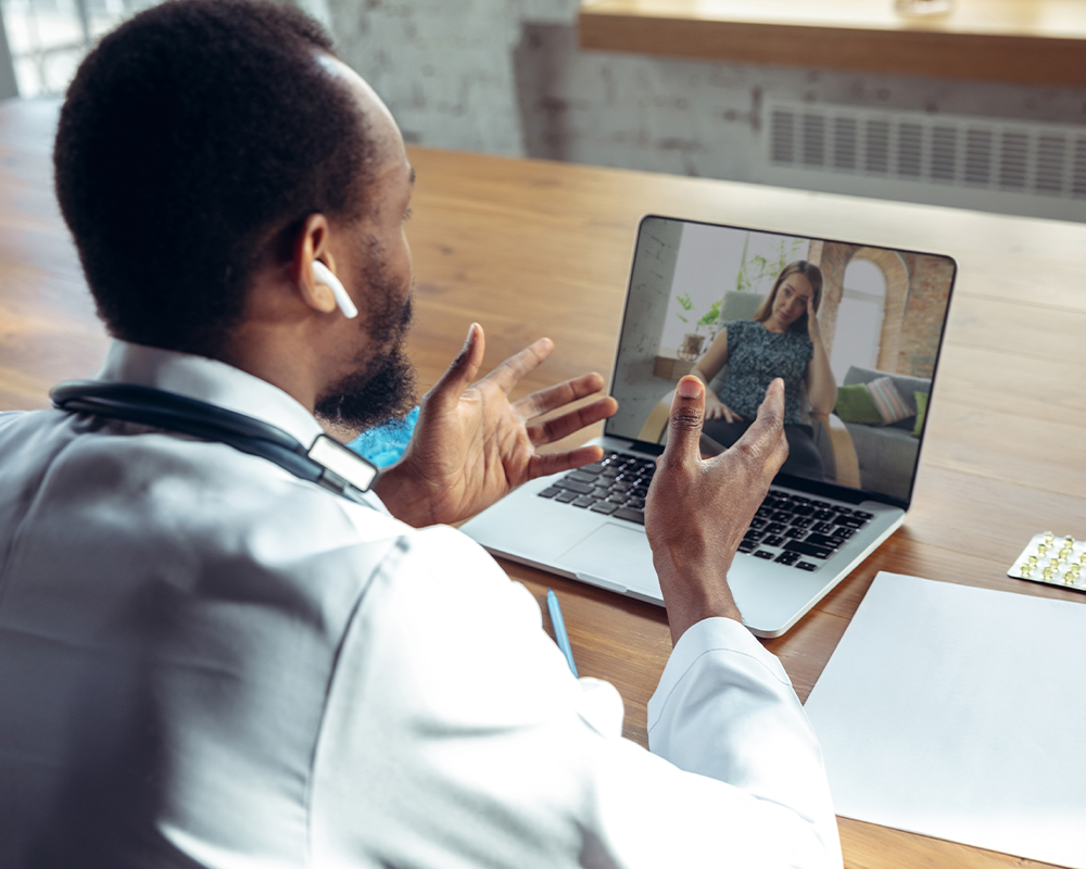 Doctor sees patient for his medical practice via telemedicine options due to COVID 19 restrictions