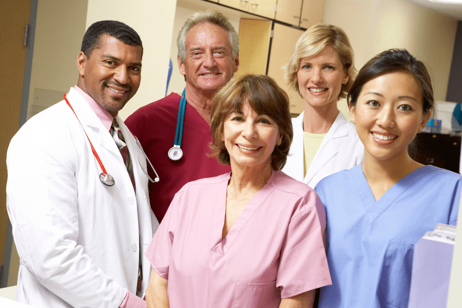 Five medical professionals pose for a photograph in their medical practice.